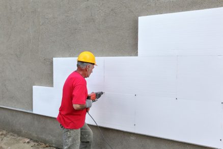 Robotník zatepľuje dom polystyrénom